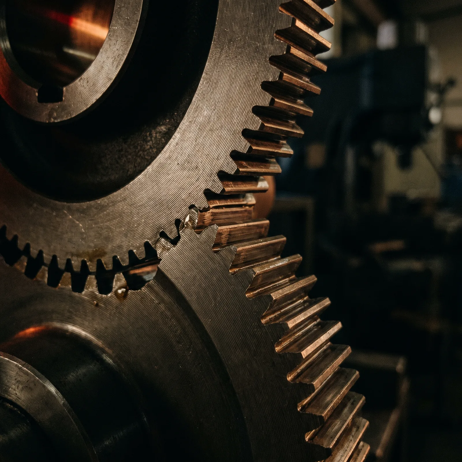Macro photograph of meshing steel gear teeth with machining marks visible.